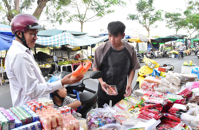 Ông Nguyễn Văn Mỹ (bên trái) chọn mua mứt Tết.

