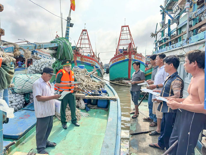 Lực lượng Đồn Biên phòng Hàm Luông tuyên truyền pháp luật cho chủ phương tiện và thuyền viên về phòng chống khai thác IUU. Ảnh: TRẦN QUỐC

