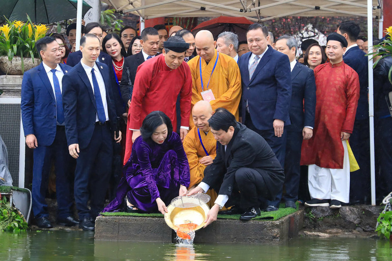 Chủ tịch nước và Phu nhân thực hiện nghi thức thả cá chép tại Hồ Hoàn Kiếm. (Ảnh: Thủy Nguyên)
