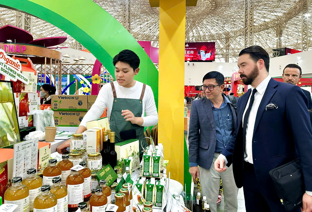 Du khách quốc tế quan tâm sản phẩm mật hoa dừa hữu cơ của tỉnh Vĩnh Long.