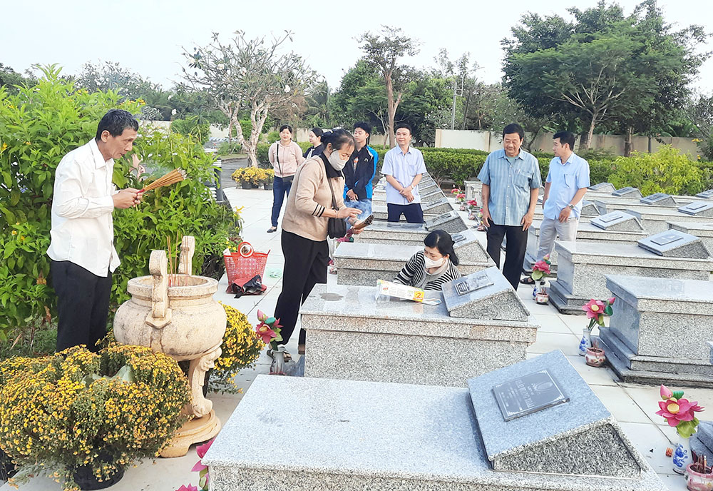 Ông Bùi Long Ửng (bên trái) thắp hương viếng mộ người thân, đồng đội tại Nghĩa trang Liệt sĩ tỉnh.