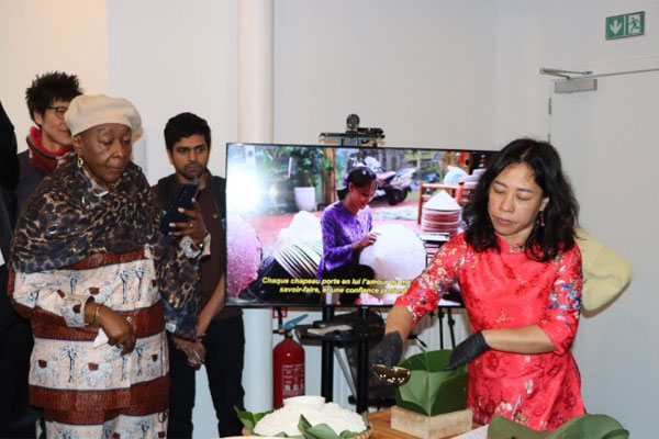 Chị Nguyễn Thị Liên, Việt kiều tại Brussels, giới thiệu cách gói bánh chưng. (Ảnh: HƯƠNG GIANG/TTXVN)