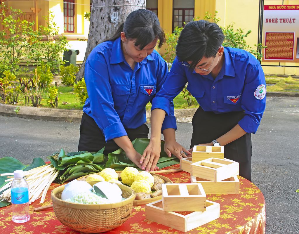 Bạn trẻ trải nghiệm gói bánh chưng vào dịp Giỗ Tổ Hùng Vương. 

