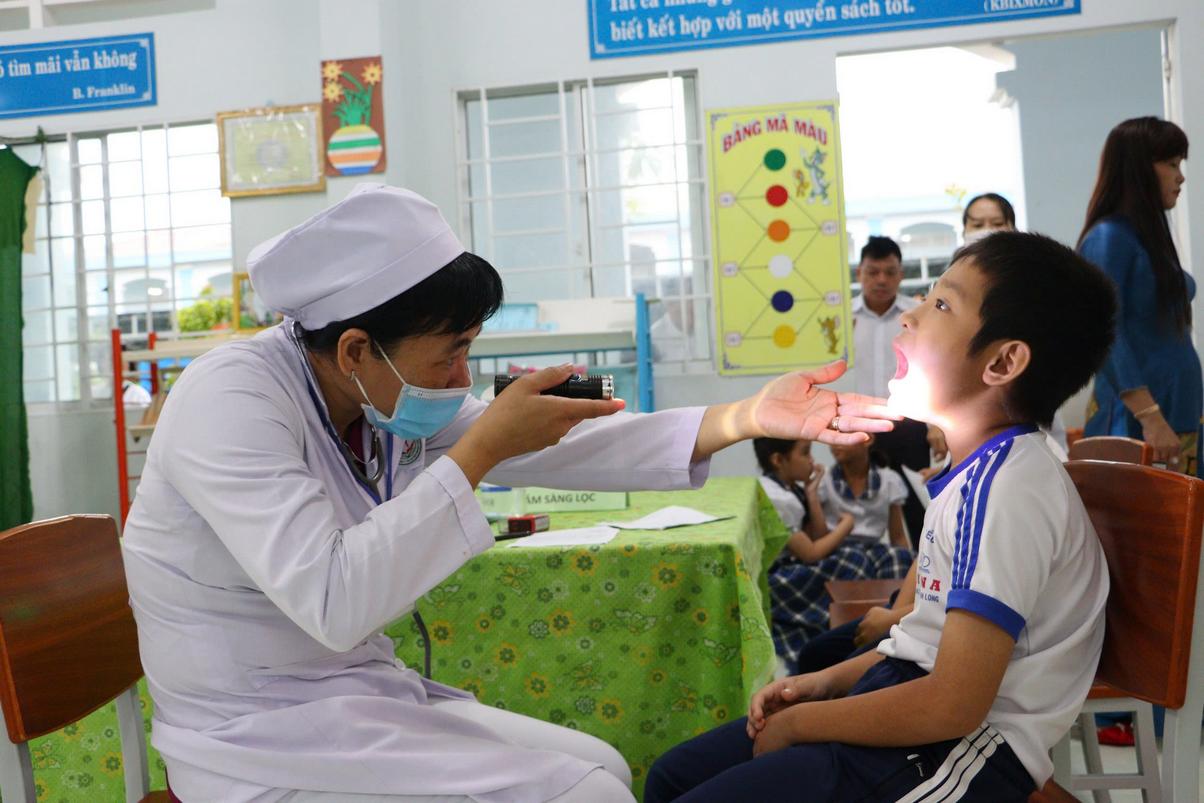 Bác sĩ Trung tâm Y tế huyện Mang Thít khám sàng lọc trước khi tiêm vaccine sởi - rubella cho trẻ em.