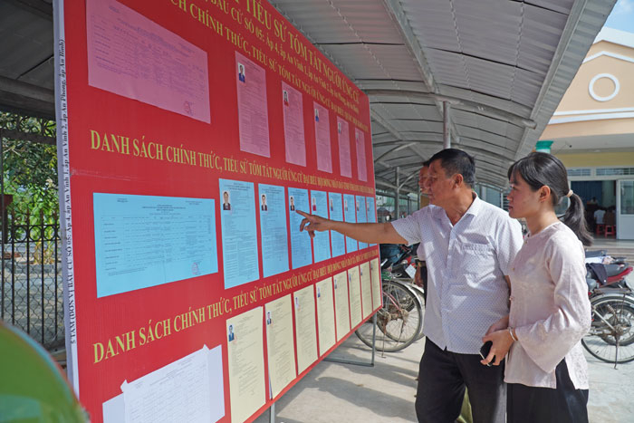 Cử tri xã Mỏ Cày tìm hiểu thông tin các ứng cử viên đại biểu HĐND tỉnh. Ảnh: PHAN HÂN

