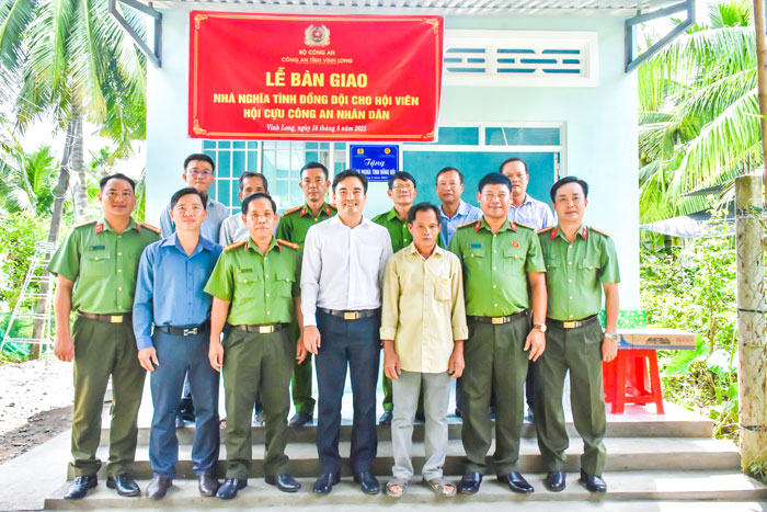 Đại tá Sơn Chí Hùng- Phó Giám đốc Công an tỉnh trao quà và chụp ảnh lưu niệm tại lễ bàn giao nhà đồng đội hỗ trợ hội viên Hội Cựu Công an nhân dân.

