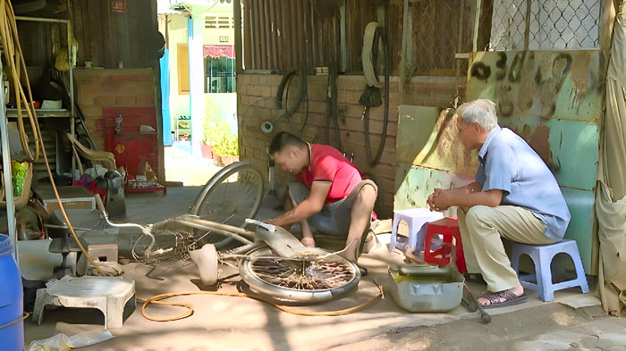 Phong cặm cụi bên công việc vá xe.