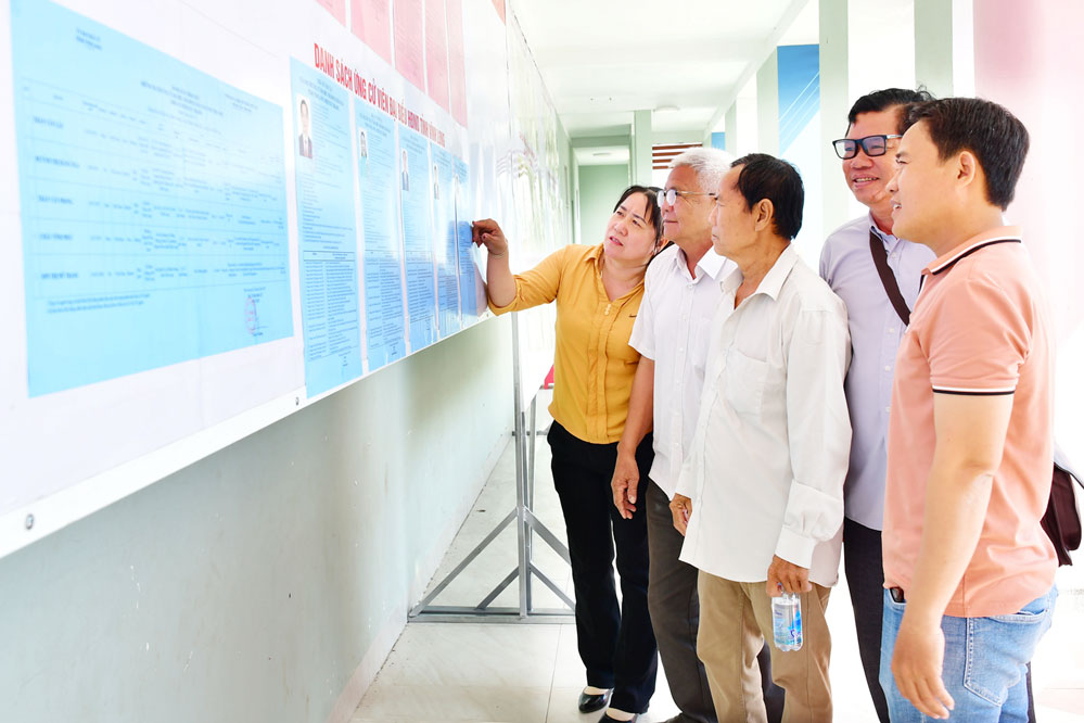 Cử tri xã Long Vĩnh tìm hiểu tiểu sử người ứng cử đại biểu Quốc hội và HĐND tỉnh được niêm yết tại hội trường Đảng ủy xã.