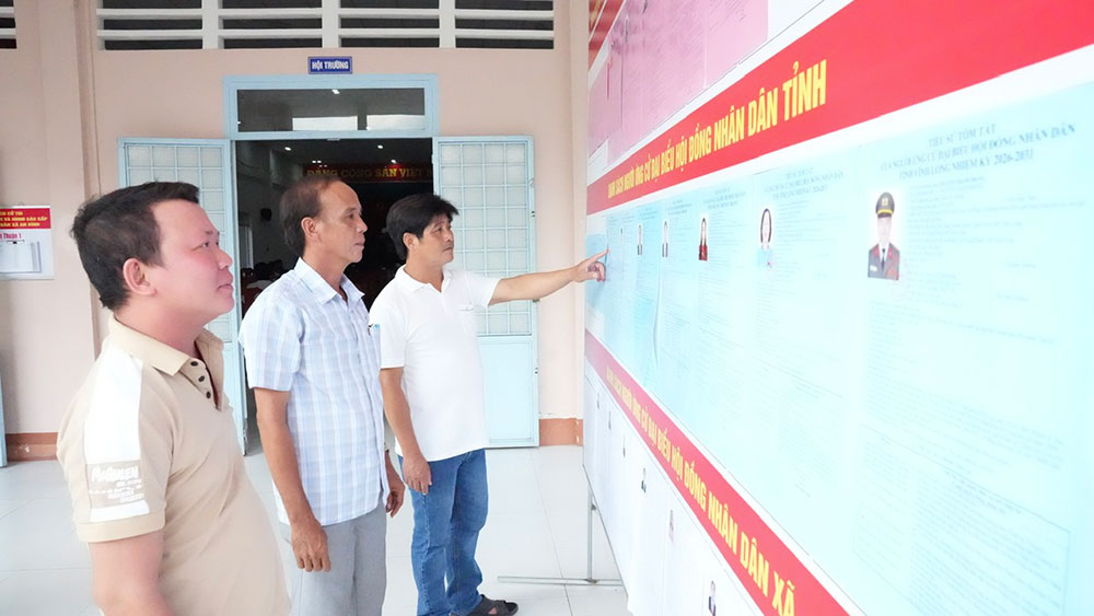 Cử tri xã An Bình xem tóm tắt tiểu sử các ứng cử viên.
