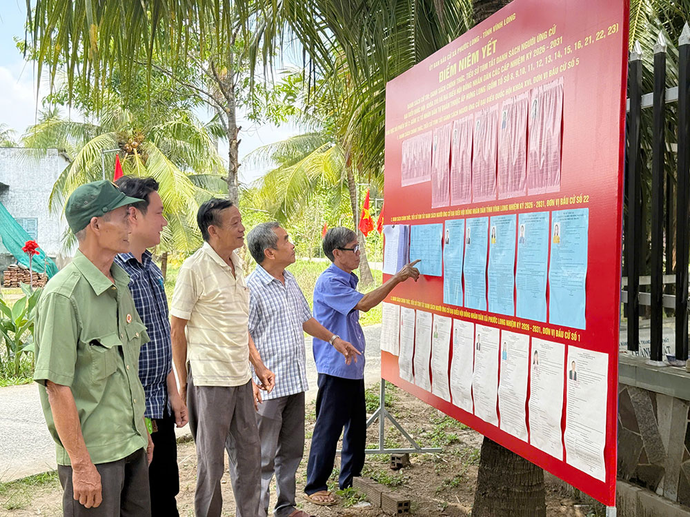 Cán bộ và nhân dân xem tiểu sử của các ứng cử viên đại biểu Quốc hội khoá XVI và đại biểu HĐND tỉnh, xã nhiệm kỳ 2026 - 2031 tại Điểm bầu cử số 1, ấp Hưng Long, xã Phước Long. Ảnh: Xuân Thi

