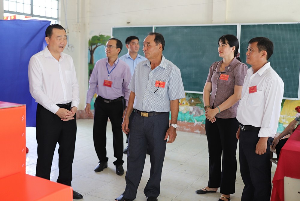 Đồng chí Nguyễn Minh Dũng nghe lãnh đạo tổ bầu cử số 5 báo cáo tình hình bầu cử.