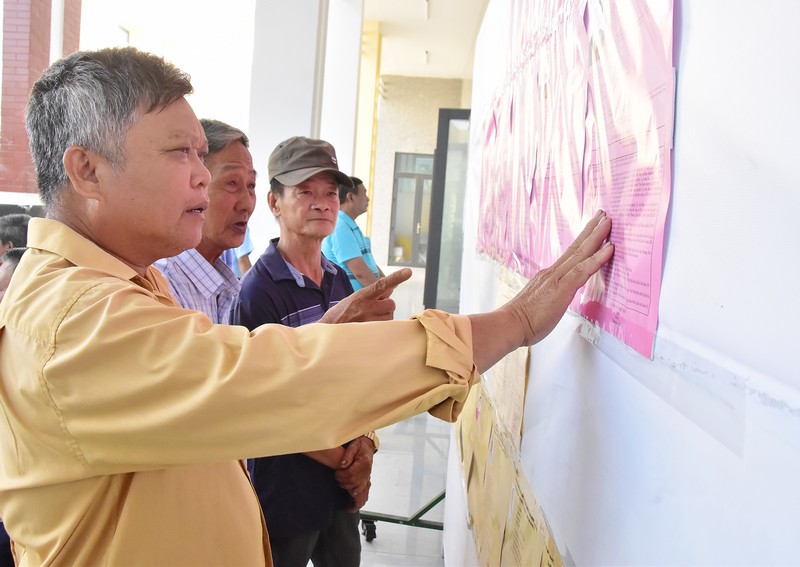 Cử tri xã Hoà Minh xem tiểu sử ứng cử viên được niêm yết tại địa phương.