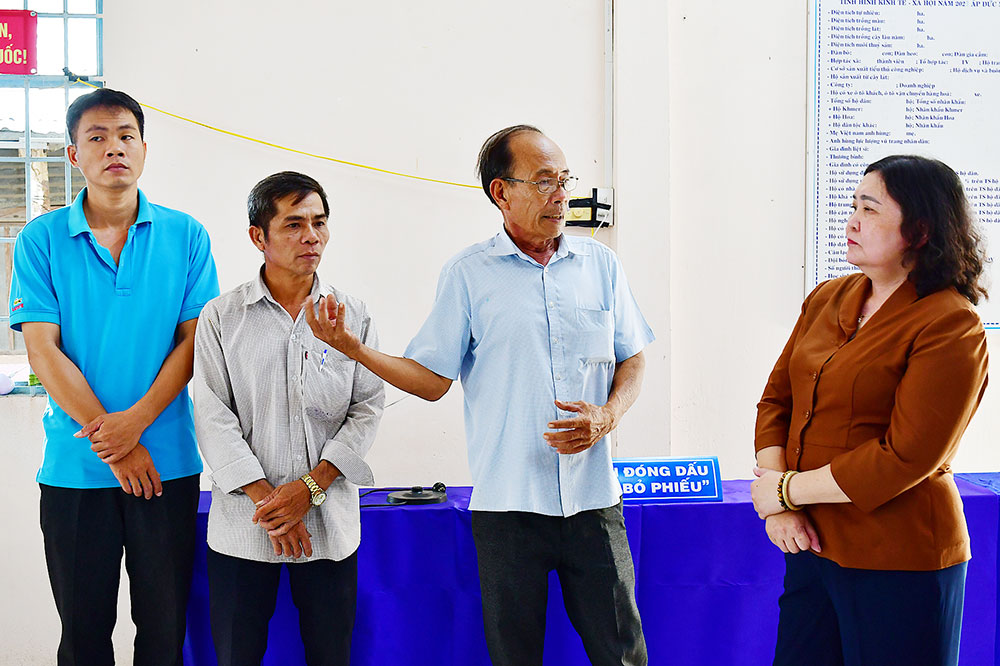 Đồng chí Hồ Thị Hoàng Yến (bên phải) gặp gỡ, động viên các thành viên Khu vực bỏ phiếu số 23, xã Nhị Long.
