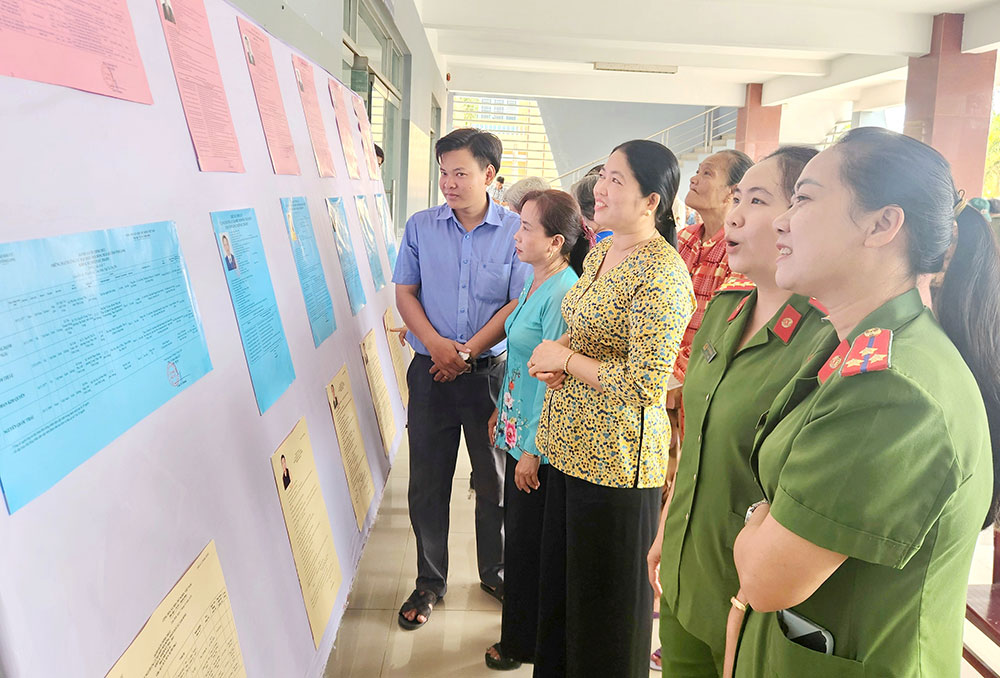 Cử tri 2 xã quan tâm tìm hiểu về tiểu sử các ứng cử viên.