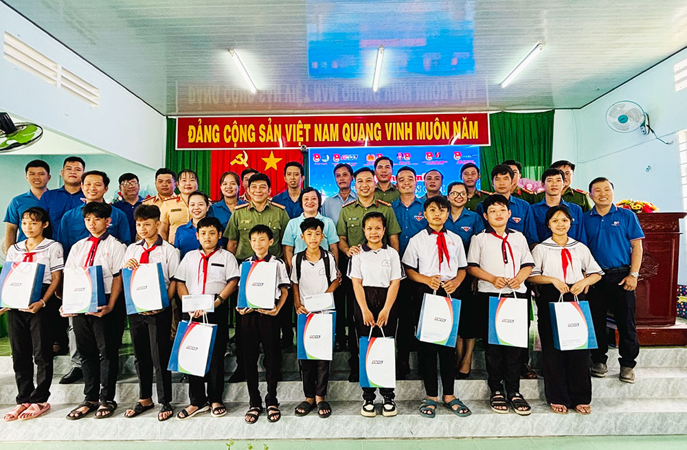 Đại biểu và các em học sinh nhận quà chụp ảnh lưu niệm.