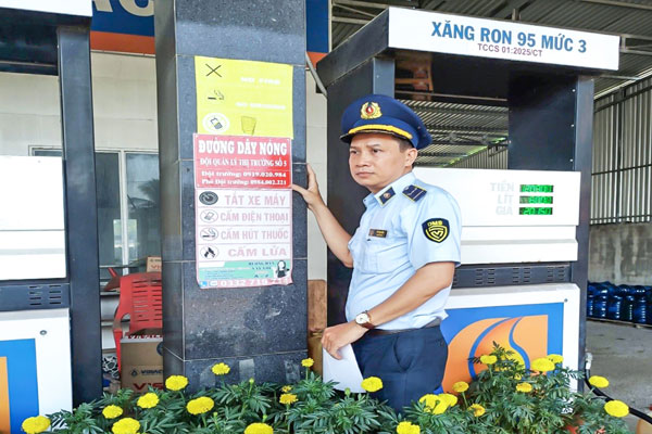 Đội Quản lý thị trường số 5 dán thông tin đường dây nóng tại cửa hàng kinh doanh xăng dầu.

