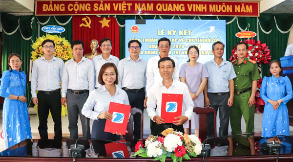 Lãnh đạo xã Ba Tri ký kết thỏa thuận hợp tác về chuyển đổi số tại địa phương. Ảnh: TRÀ DŨNG

