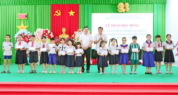 Lãnh đạo Sở GD-ĐT và nhà tài trợ trao học bổng cho học sinh.