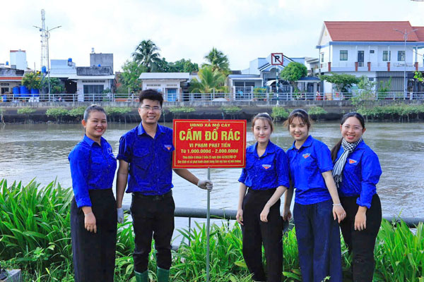 Đoàn viên, thanh niên gắn biển báo nhắc nhở mọi người chung tay giữ gìn vệ sinh môi trường.

