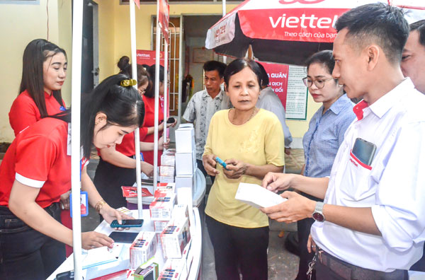 Nhân viên Viettel hỗ trợ người dân cài đặt phần mềm trên điện thoại thông minh để tiếp cận chuyển đổi số.

