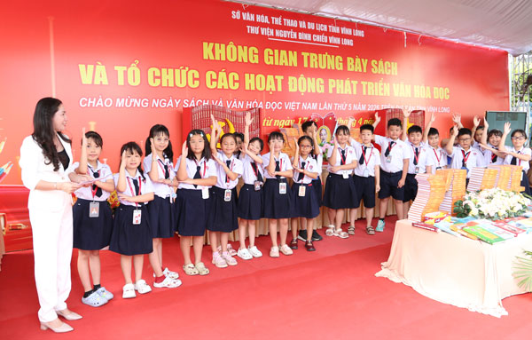 Học sinh hào hứng tham gia trò chơi đố vui có thưởng được Thư viện Nguyễn Đình Chiểu Vĩnh Long tổ chức tại triển lãm sách.

