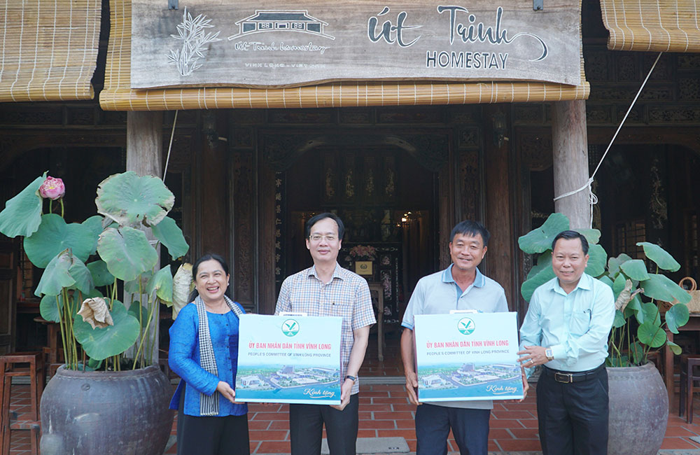 Đoàn khảo sát tặng quà và chụp ảnh lưu niệm tại điểm du lịch Homestay Út Trinh (xã An Bình).