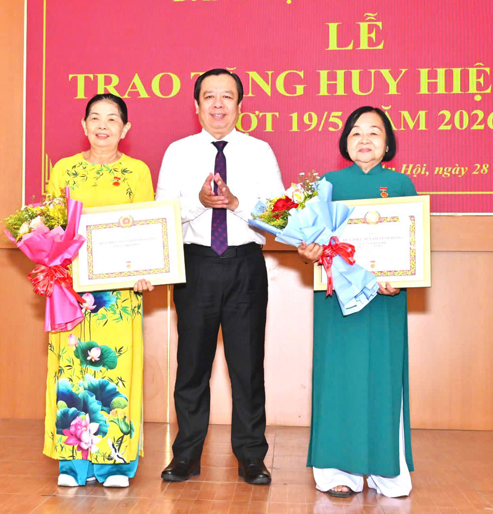 Đồng chí Bùi Minh Tuấn - Bí thư Đảng ủy phường An Hội trao Huy hiệu 50 năm tuổi Đảng cho đảng viên. Ảnh: HỒNG QUỐC.