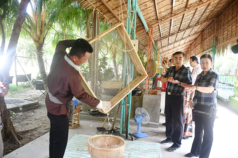 Đại biểu và du khách tìm hiểu, trải nghiệm cách làm bánh cốm gạo.