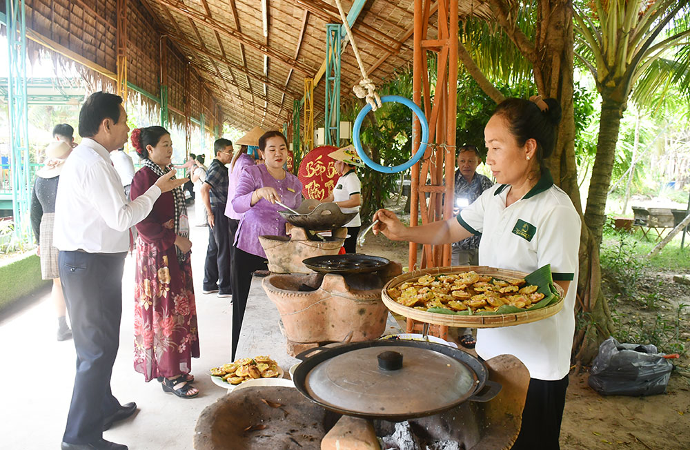 Đại biểu xem và tìm hiểu cách đổ bánh khọt.