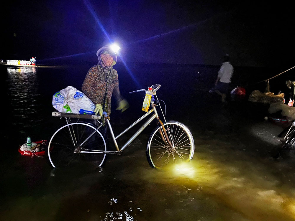 Khi triều rút xuống, bãi cát trải dài ra xa hàng cây số, xã viên có thể mang xe máy, xe đạp ra sân nghêu để chở nghêu.