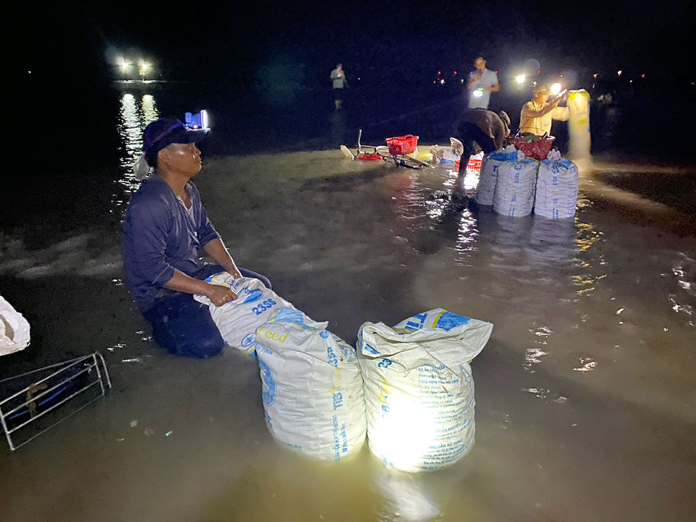 Các xã viên ngồi nghỉ xả hơi ngay tại chỗ và kiểm tra số lượng nghêu bắt được trong đêm.