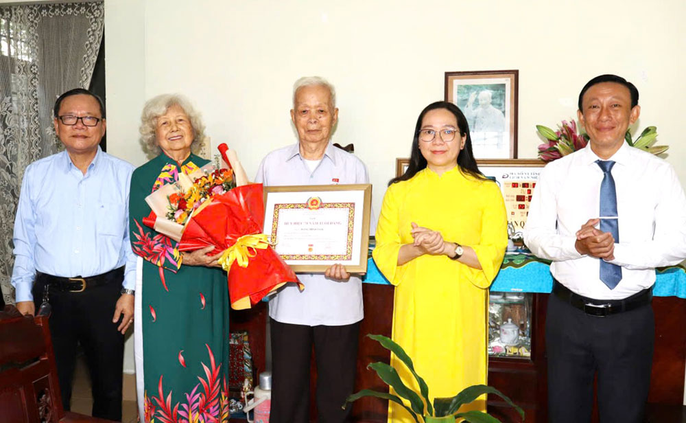 Đồng chí Nguyễn Thị Hồng Nhung - Phó Chủ tịch Thường trực Ủy ban MTTQ Việt Nam tỉnh trực tiếp đến nhà trao Huy hiệu 70 năm tuổi Đảng cho đảng viên Đặng Minh Tâm. Ảnh: NGỌC HÂN.