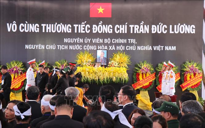 Nghi lễ thả hoa vào huyệt. Ảnh: Phạm Cường/TTXVN