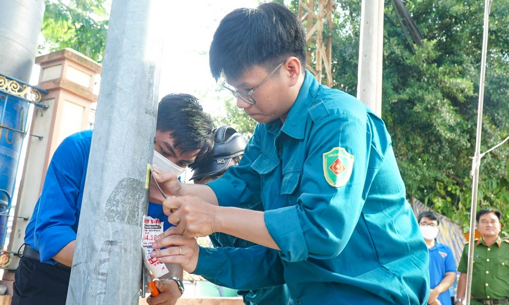 Lực lượng dân quân tự vệ Phường 1 (TP Vĩnh Long) tháo gỡ quảng cáo “tín dụng đen” dán trên cột tín hiệu giao thông.
