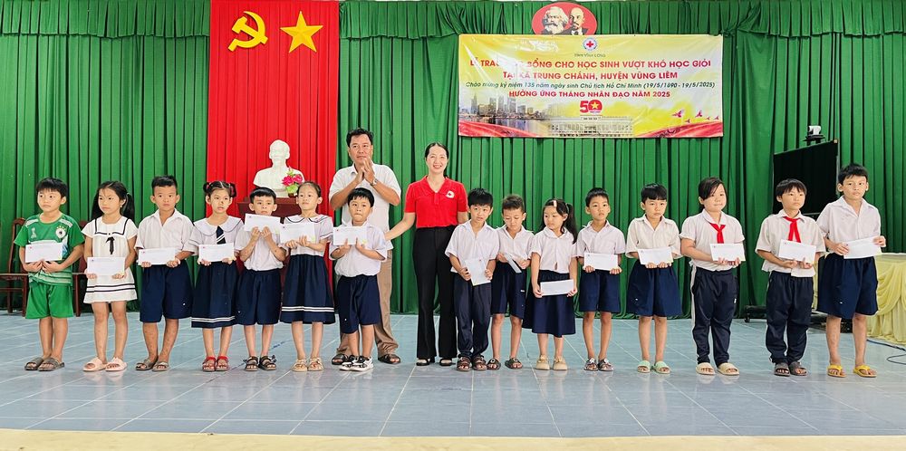 Lãnh đạo Hội Chữ thập đỏ tỉnh Vĩnh Long và UBND xã Trung Chánh trao học bổng cho học sinh vượt khó học giỏi.