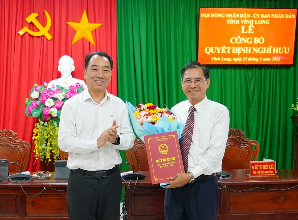 Ông Lữ Quang Ngời- Phó Bí thư Tỉnh ủy, Chủ tịch UBND tỉnh trao quyết định nghỉ hưu và tặng hoa ông Nguyễn Đắc Phương.