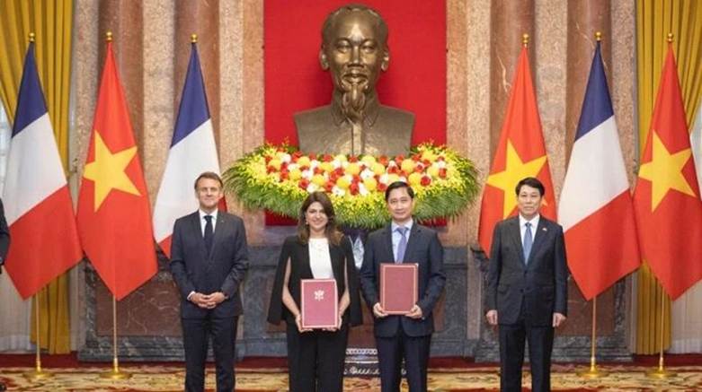 Ông Ngô Chí Dũng, Tổng Giám đốc kiêm Chủ tịch HĐQT Công ty Vaccine Việt Nam (VNVC) và bà Zainab Sadat Qayyum, Chủ tịch Sanofi Đông Nam Á-Ấn Độ trao văn kiện thỏa thuận hợp tác chuyển giao công nghệ sản xuất vaccine của Sanofi tại Nhà máy Vaccine và Sinh phẩm VNVC trước sự chứng kiến của Chủ tịch nước Lương Cường và Tổng thống Pháp Emmanuel Macron. (Ảnh: SƠN TÙNG)

