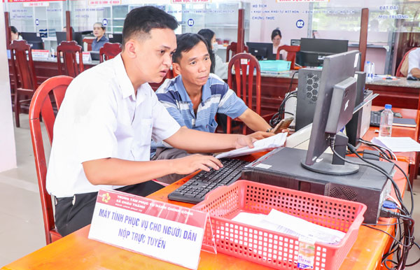 Công chức Trung tâm Phục vụ hành chính công xã Châu Thành hướng dẫn người dân nộp hồ sơ trực tuyến.

