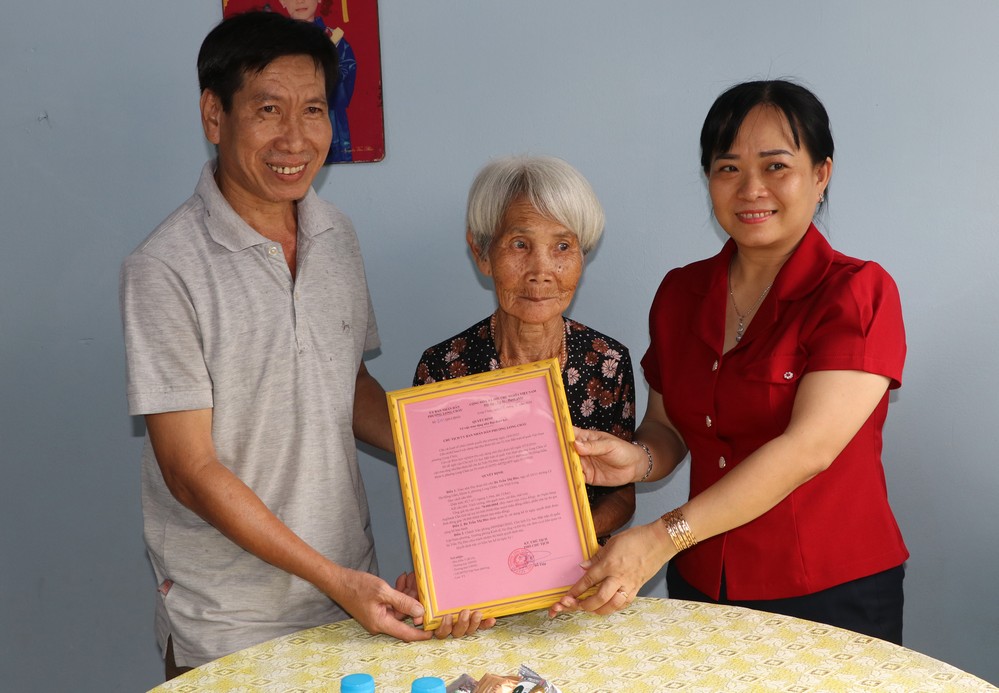 Đồng chí Lâm Thị Kim Thanh- Ủy viên Thường vụ, Chủ tịch Ủy ban MTTQ Việt Nam phường Long Châu trao quyết định tặng nhà đại đoàn kết cho gia đình bà Trần Thị Đào.