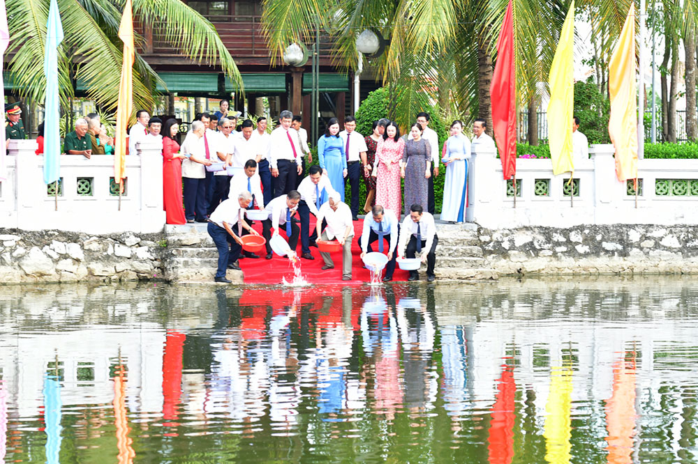 Lãnh đạo tỉnh tham gia hoạt dộng thả cá xuống ao sen.