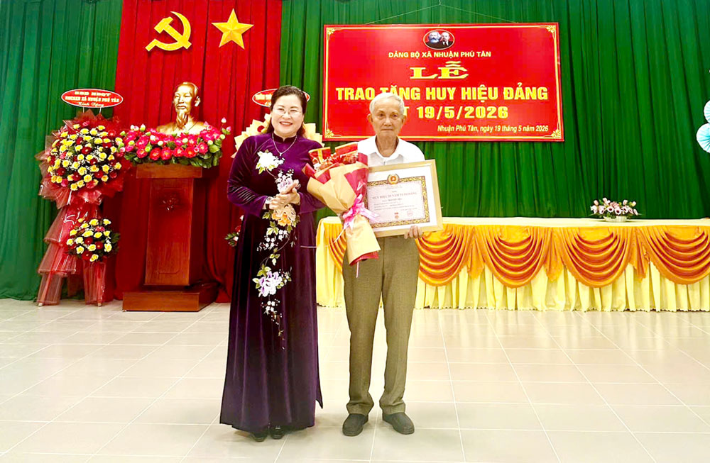 Đồng chí Nguyễn Thị Minh Trang trao tặng Huy hiệu Đảng cho các đảng viên cao niên tuổi Đảng tại xã Nhuận Phú Tân.