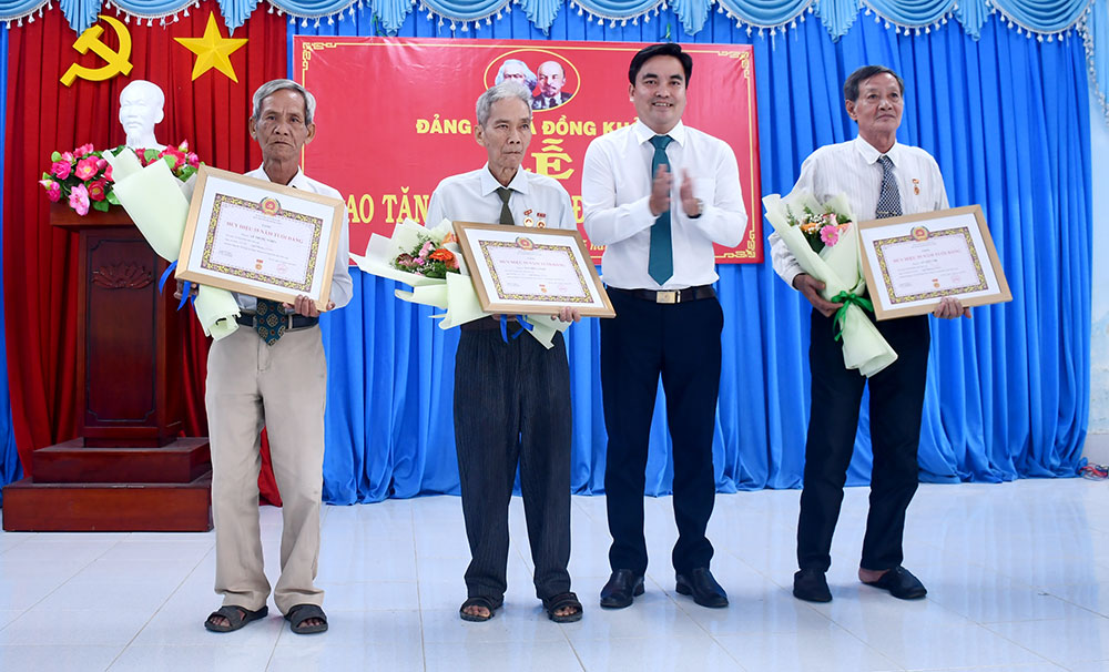 Đồng chí Nguyễn Quốc Hưng - Bí thư Đảng ủy xã Đồng Khởi trao tặng huy hiệu đảng cho các đảng viên cao niên tuổi đảng.