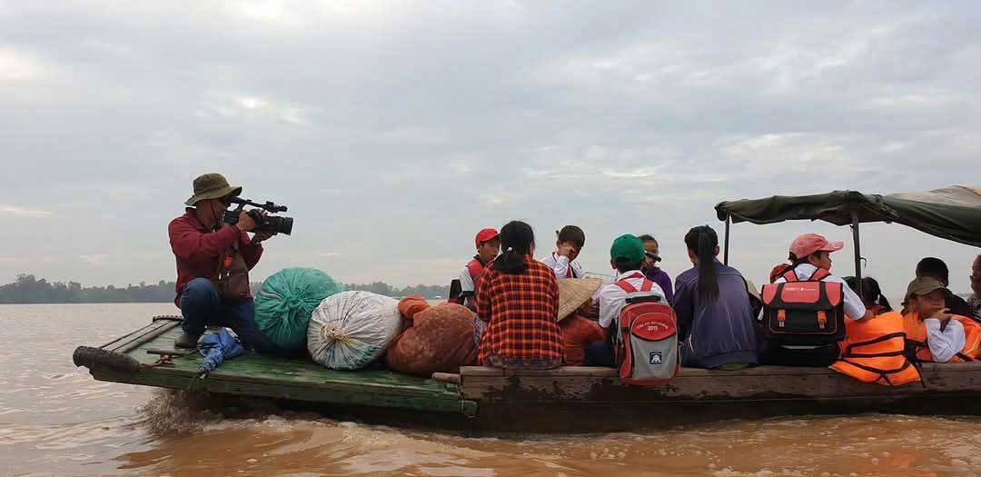 Vượt sông tìm con chữ giữa mùa nước ven biên. Ảnh: DOÃN ĐAN