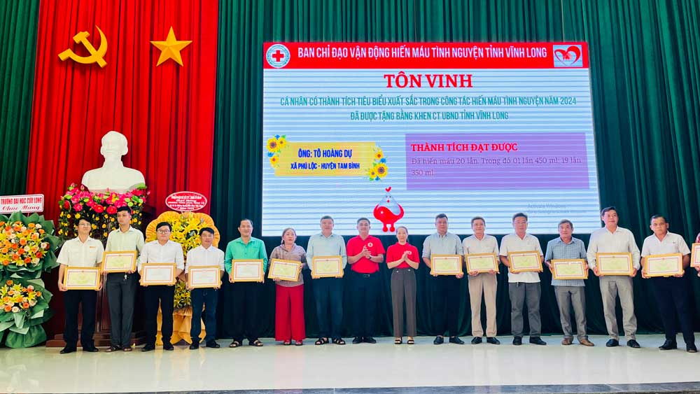 Bà Nguyễn Thụy Yến Phương- Chủ tịch Hội Chữ thập đỏ và anh Trần Công Khánh- Bí thư Tỉnh Đoàn Vĩnh Long, đại diện trao bằng khen của UBND tỉnh cho các cá nhân có thành tích tiêu biểu xuất sắc trong công tác hiến máu tình nguyện (ảnh chụp ngày 18/6).