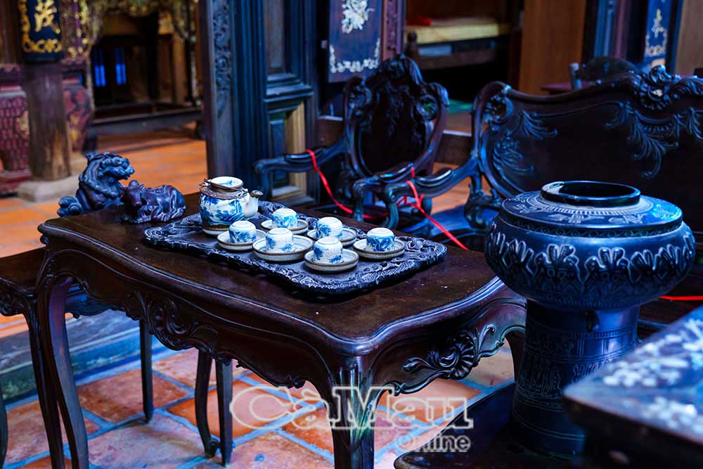 Bộ trường kỷ gỗ chạm trổ tinh xảo cùng với bộ ấm trà men lam cổ - nét thanh tao trong không gian tiếp khách truyền thống Nam Bộ.