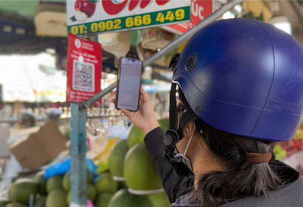 Nhiều tiểu thương bán trái cây, thịt cá... ở chợ cũng trang bị bảng mã QR.