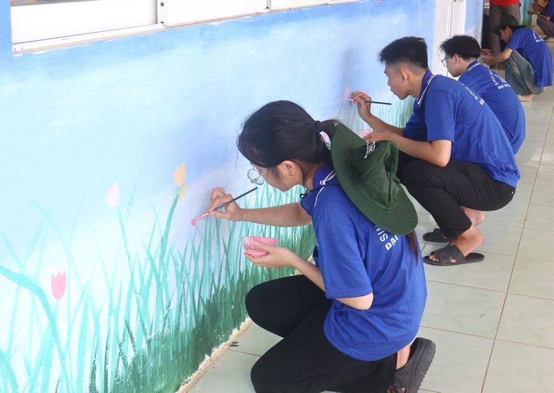 
Sinh viên điểm tô sắc màu cho mảng tường Trường Tiểu học Phú Quới C.