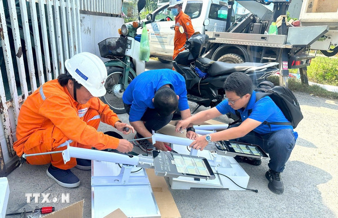 Kỹ sư Nguyễn Hoàng Thắng (phải), Tổ kỹ thuật tổng hợp, Đội bảo trì nhị thứ, Công ty Lưới điện cao thế Thành phố Hồ Chí Minh (thuộc Tổng Công ty Điện lực Thành phố Hồ Chí Minh) tham gia đội hình thanh niên tình nguyện của chương trình “Nguồn sáng văn minh, tiết kiệm”. (Ảnh: TTXVN phát)