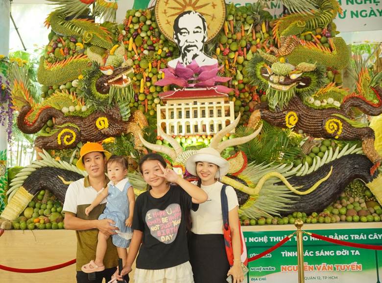 Gia đình anh Nguyễn Thắng, ngụ ở thành phố Thủ Đức cùng check in với tác phẩm nghệ thuật được tạo hình từ các loại trái cây Nam bộ.