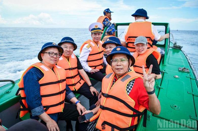 Nhà báo Lê Quốc Minh, Ủy viên Trung ương Đảng, Tổng Biên tập Báo Nhân Dân, Phó trưởng Ban Tuyên giáo và Dân vận Trung ương, Chủ tịch Hội Nhà báo Việt Nam cùng đồng hành với các cơ quan báo chí trên chiếc canô tiến vào đảo.